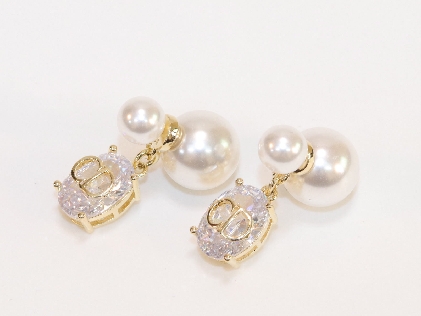 Alphabet C and D dangling stone pearl studs in platinum finish