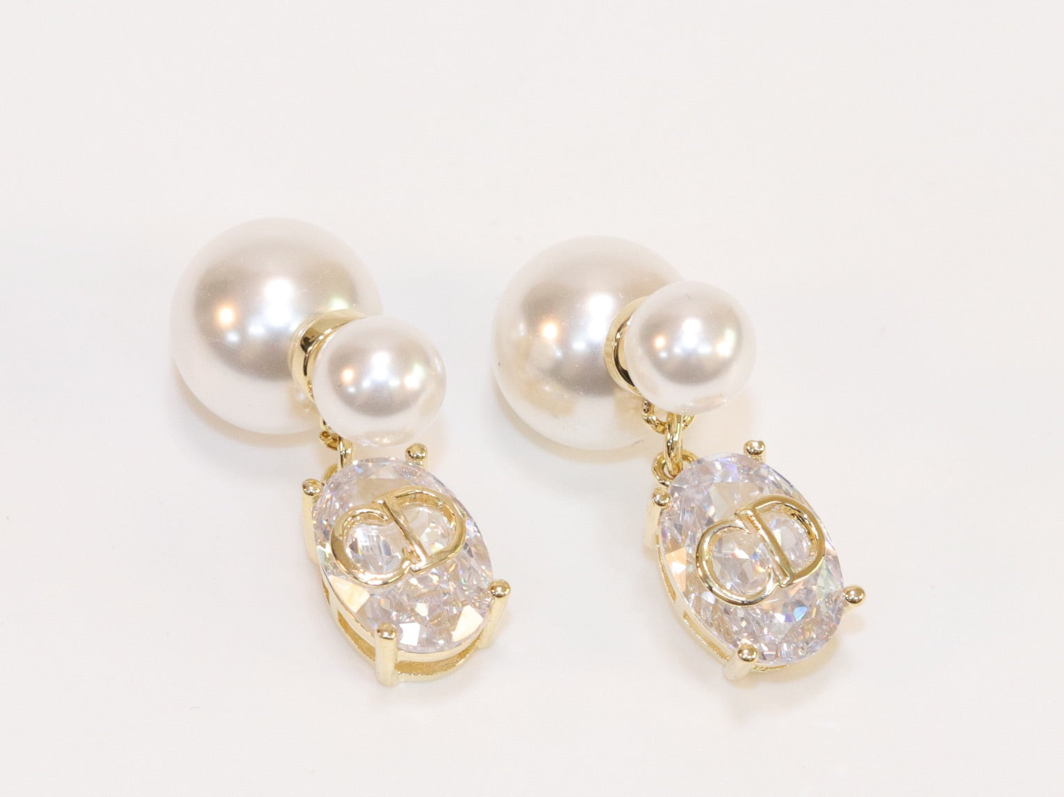 Alphabet C and D dangling stone pearl studs in platinum finish
