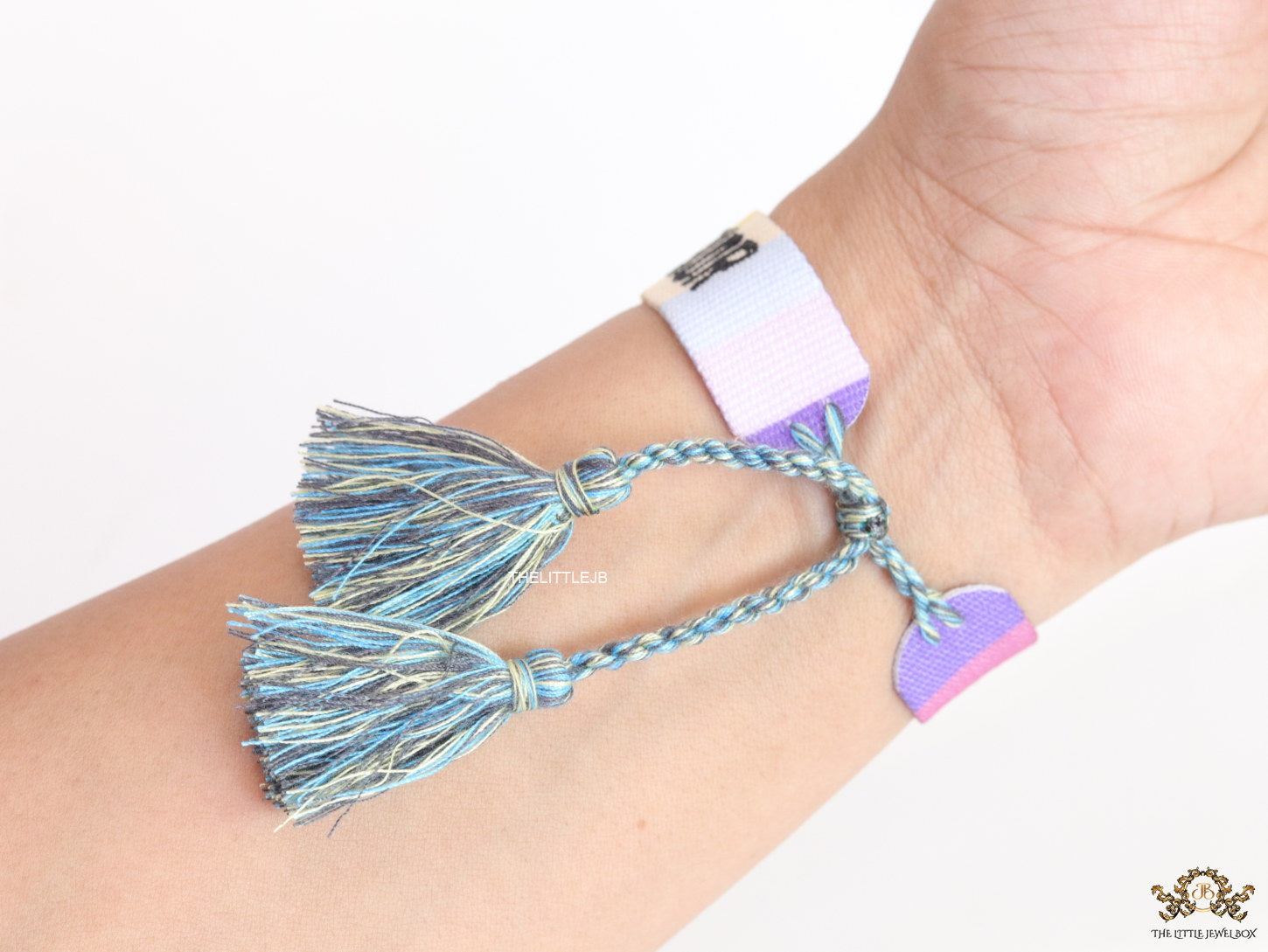 Adjustable multi color woven bracelet with black knitted alphabets and tassels