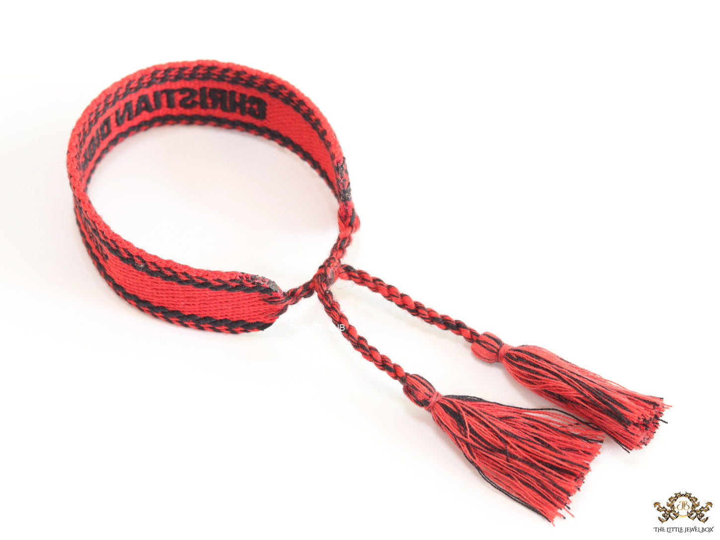 Adjustable red woven bracelet with black knitted alphabets and tassels