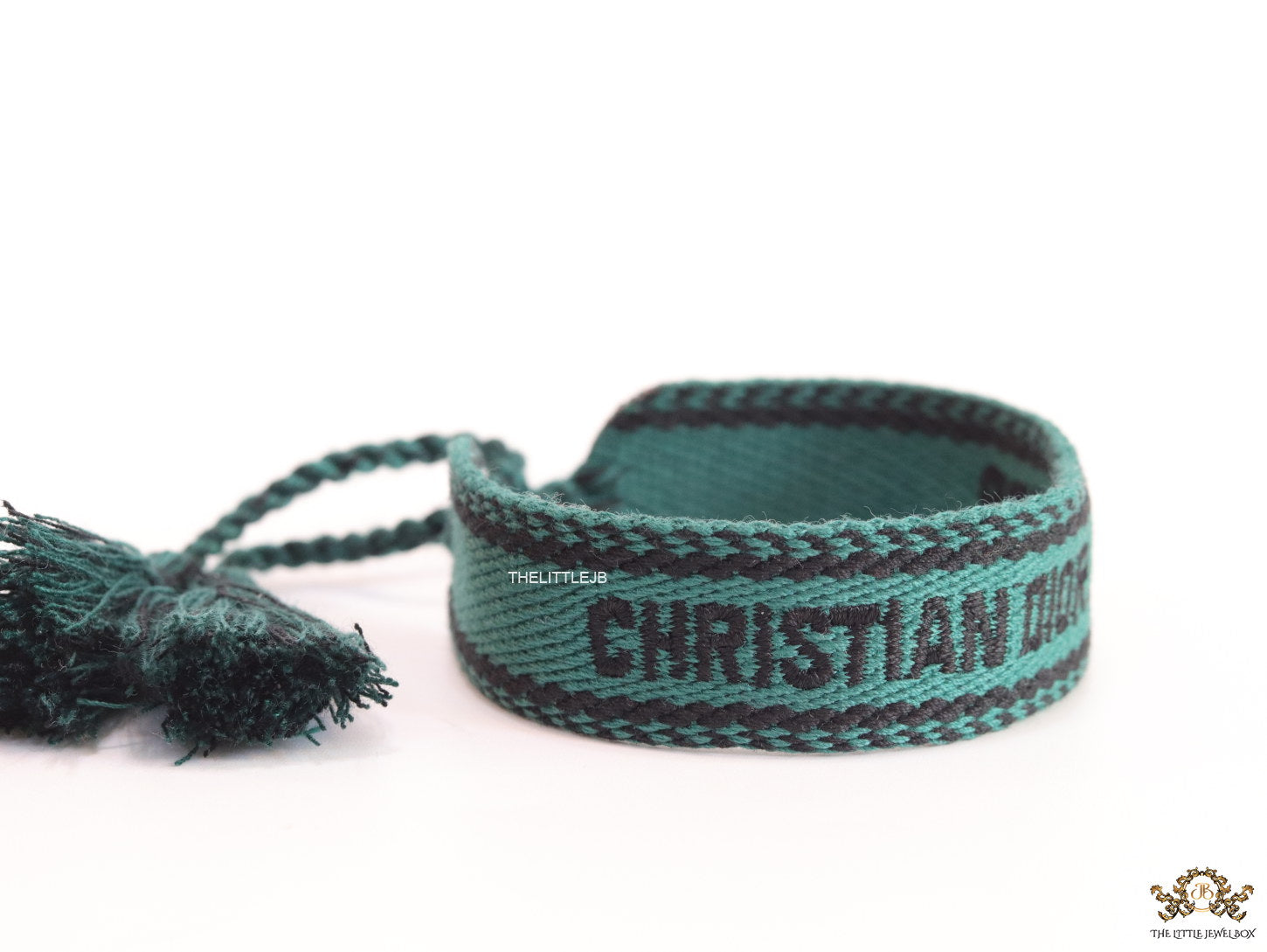 Adjustable green woven bracelet with black knitted alphabets and tassels