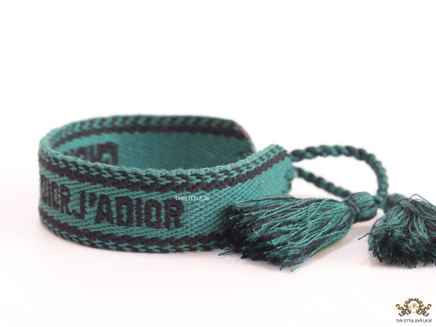 Adjustable green woven bracelet with black knitted alphabets and tassels
