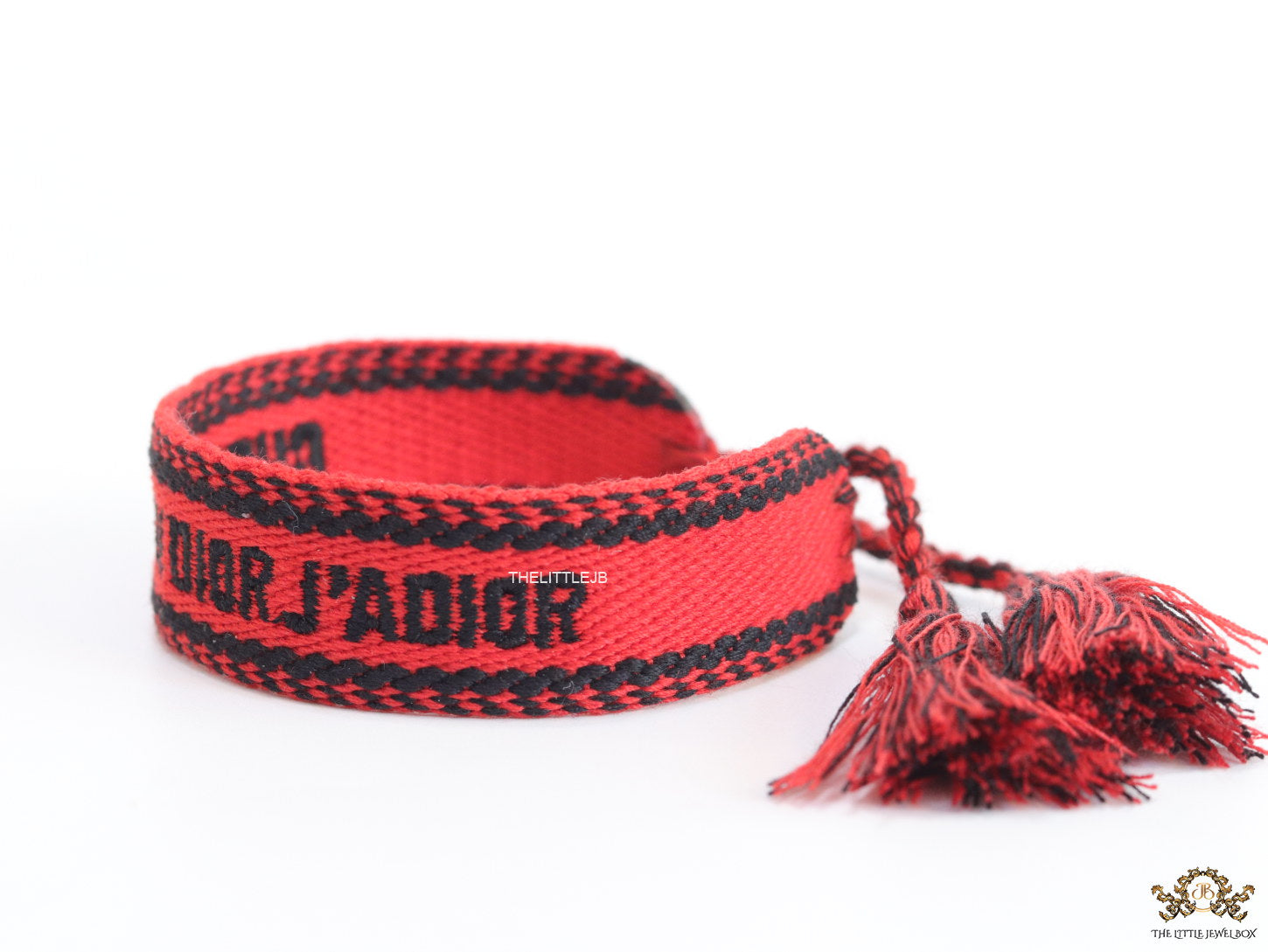 Adjustable red woven bracelet with black knitted alphabets and tassels