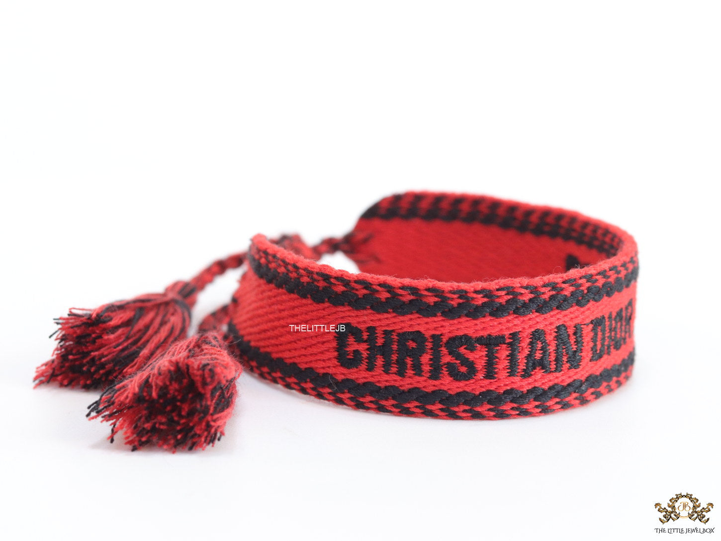 Adjustable red woven bracelet with black knitted alphabets and tassels
