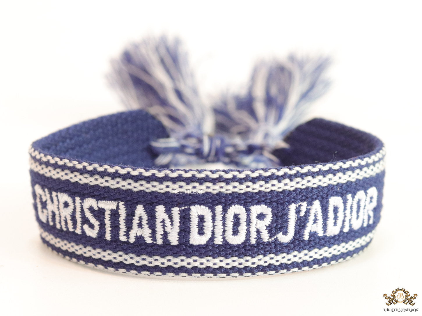 Adjustable blue woven bracelet with white knitted alphabets and tassels