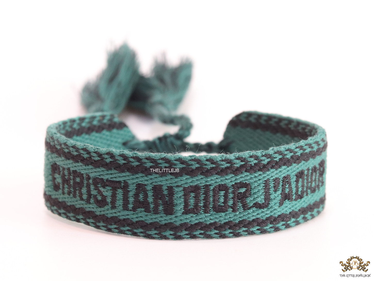 Adjustable green woven bracelet with black knitted alphabets and tassels