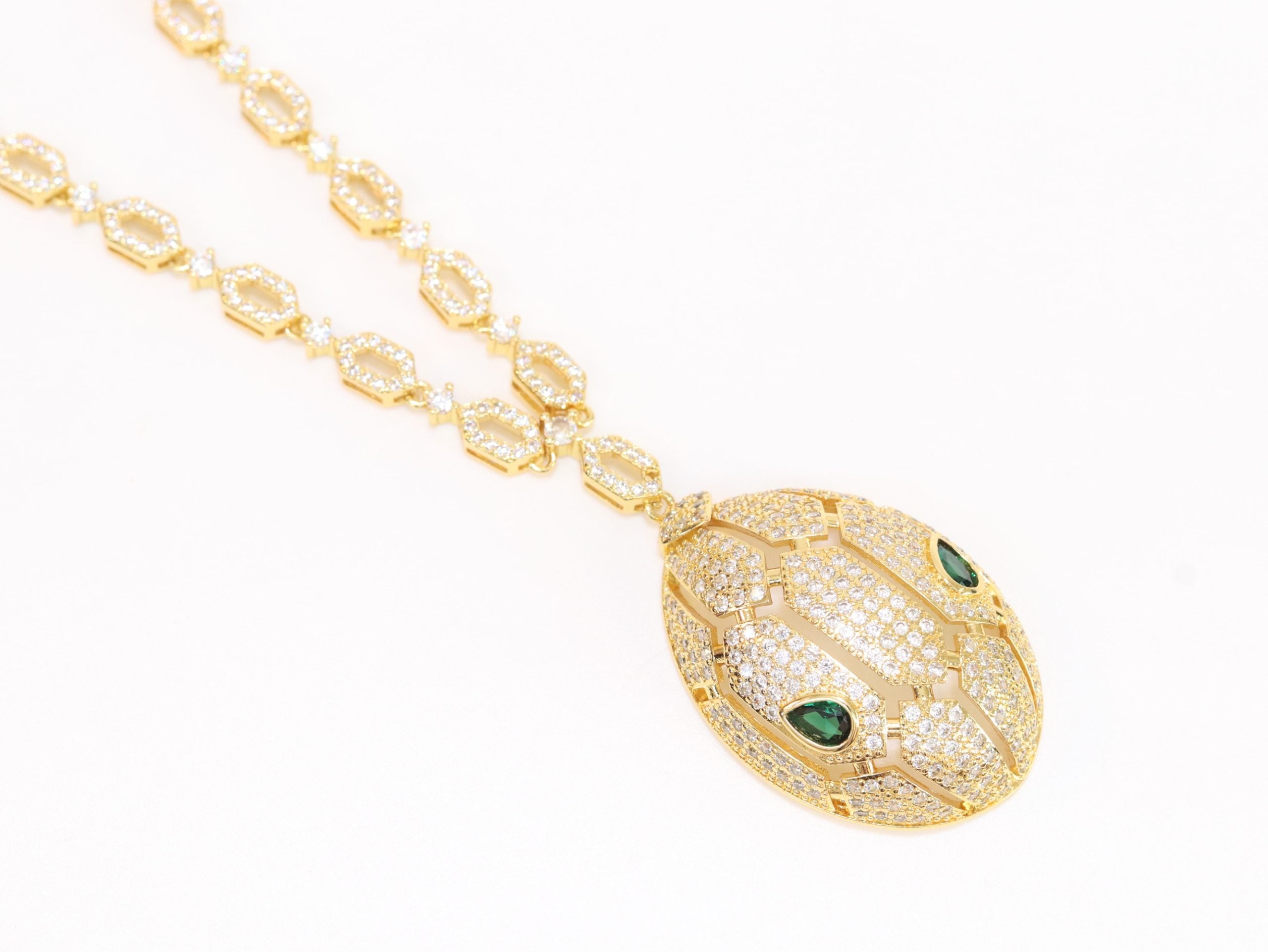 Gold Snake head pendant set with emerald detailing