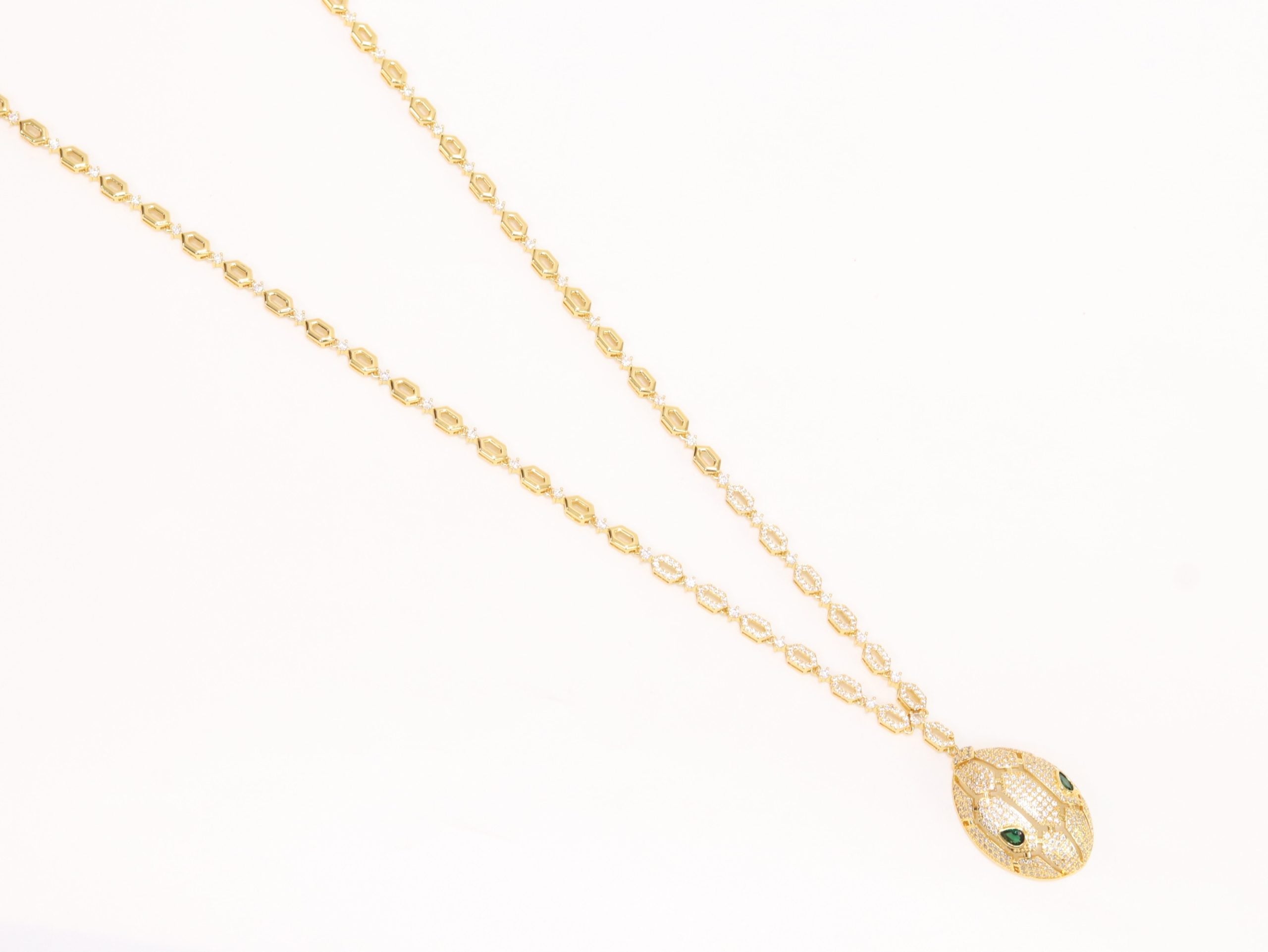 Gold Snake head pendant set with emerald detailing