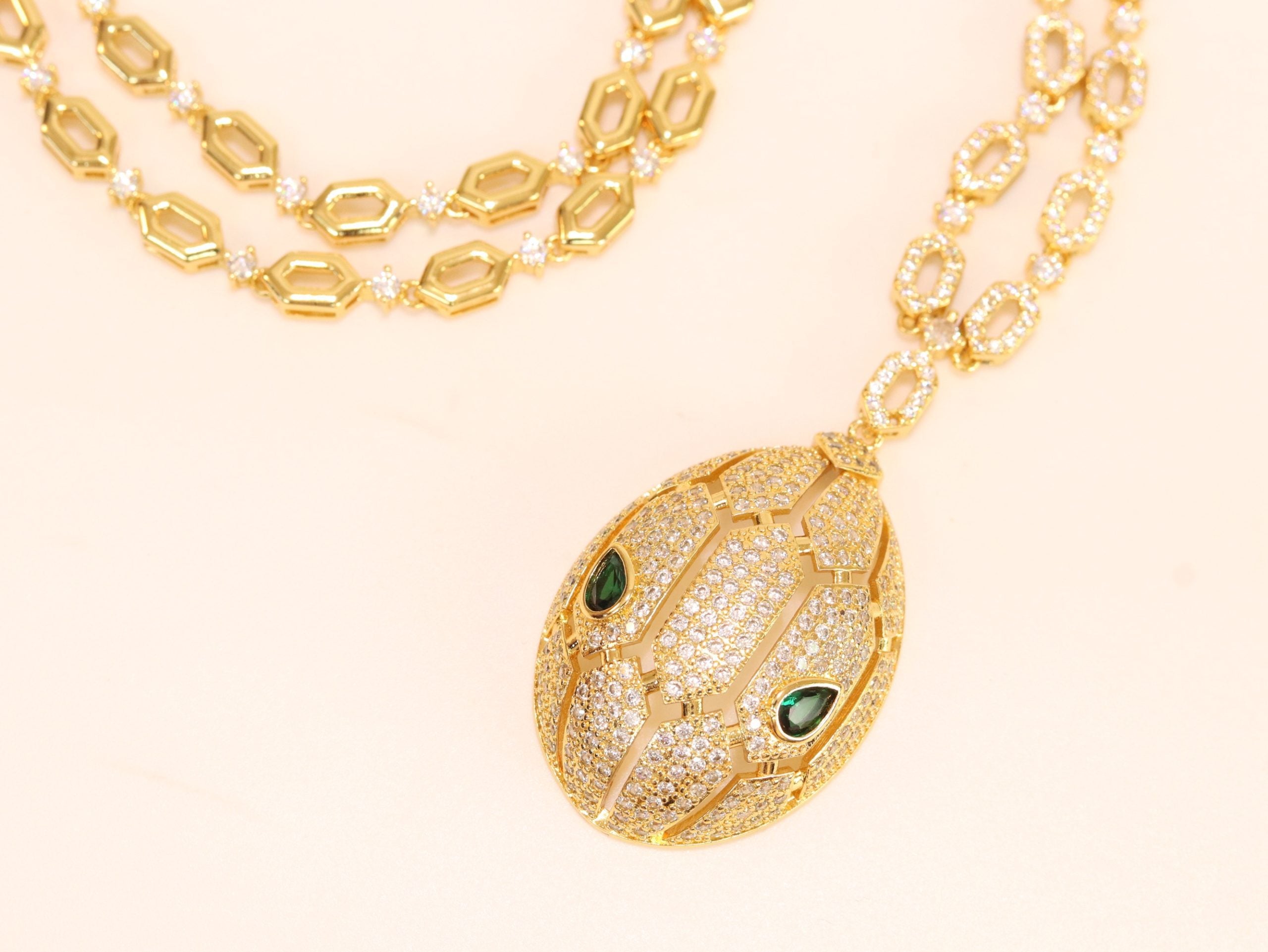 Gold Snake head pendant set with emerald detailing