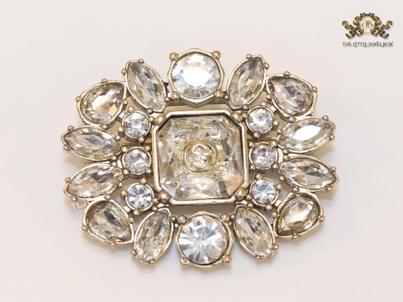 Double G brooch with uncut stones