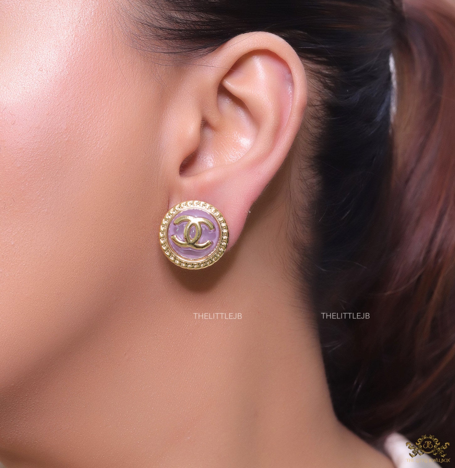Twin C motif gold plated round studs on lilac acrylic base