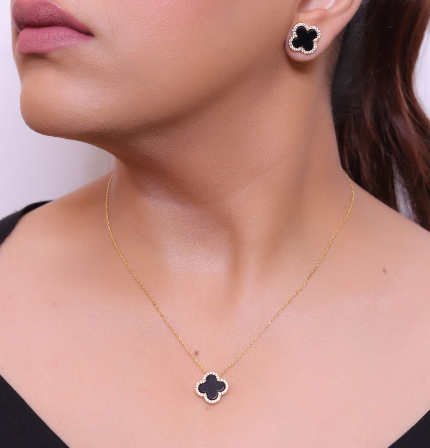 Sleek gold plated chain with cubic zirconia studded black clover shape pendant