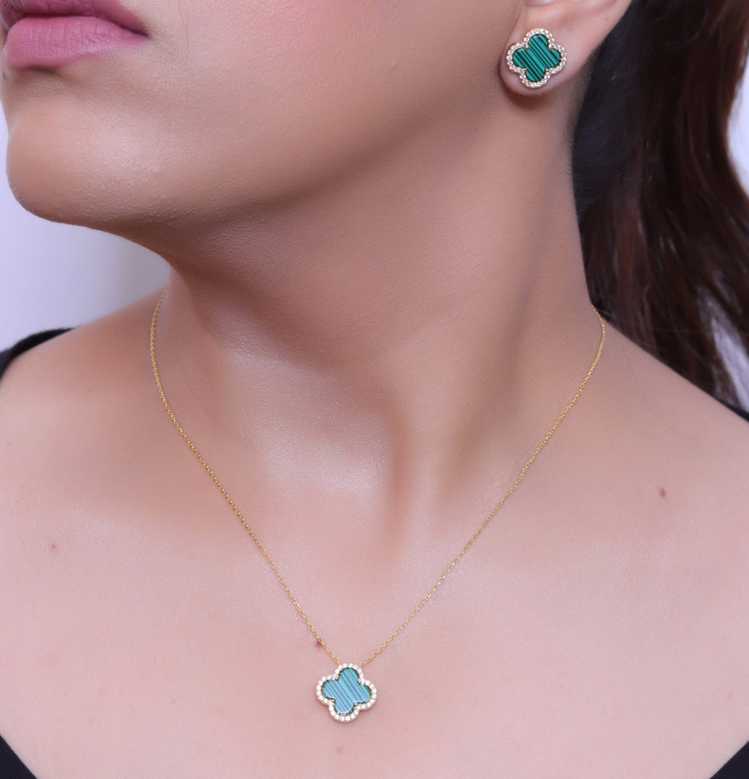 Sleek gold plated chain with cubic zirconia studded green clover shape pendant