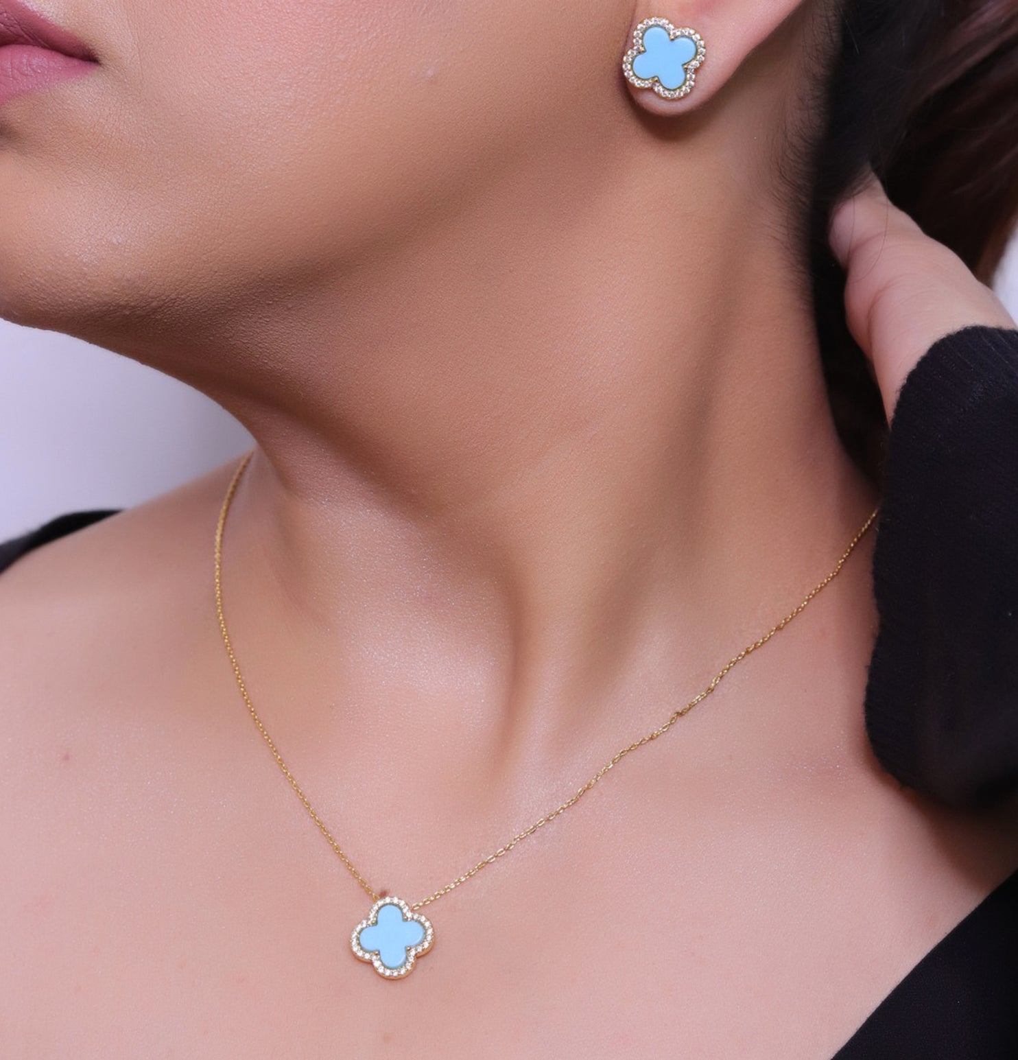 Sleek gold plated chain with cubic zirconia studded blue clover shape pendant