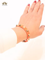 Alphabet V rockstud orange bracelet