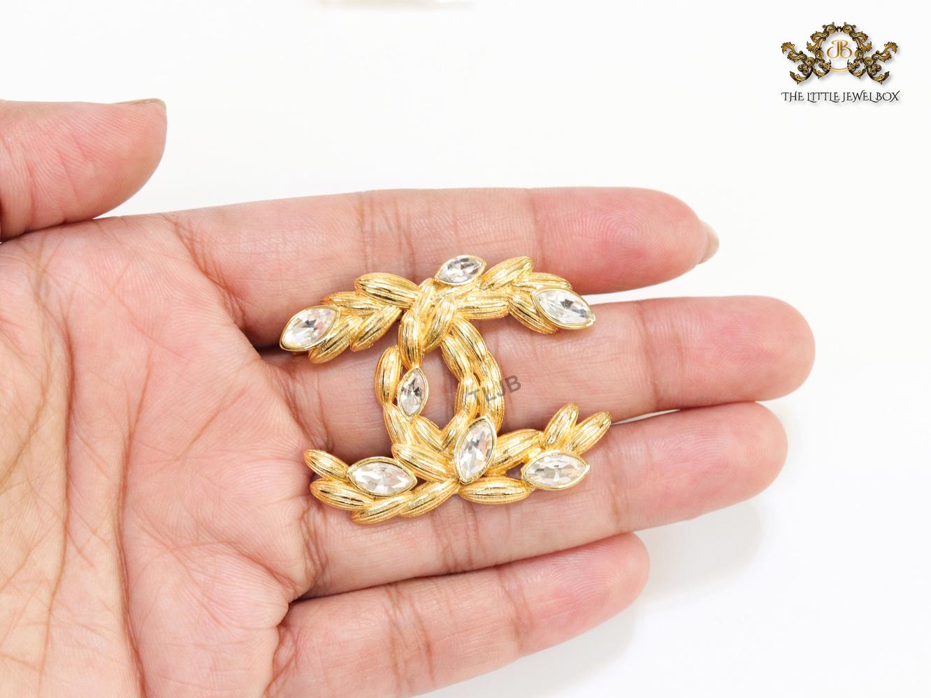 Twin C brooch in matte gold and fancy cz