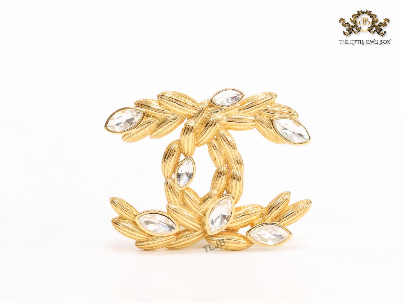 Twin C brooch in matte gold and fancy cz