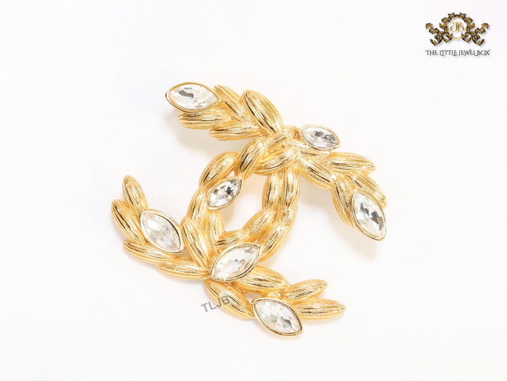 Twin C brooch in matte gold and fancy cz