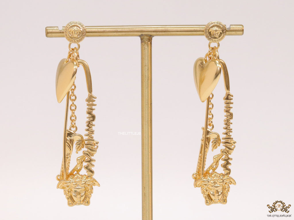 Unique golden Medusa earrings with safety pin motif