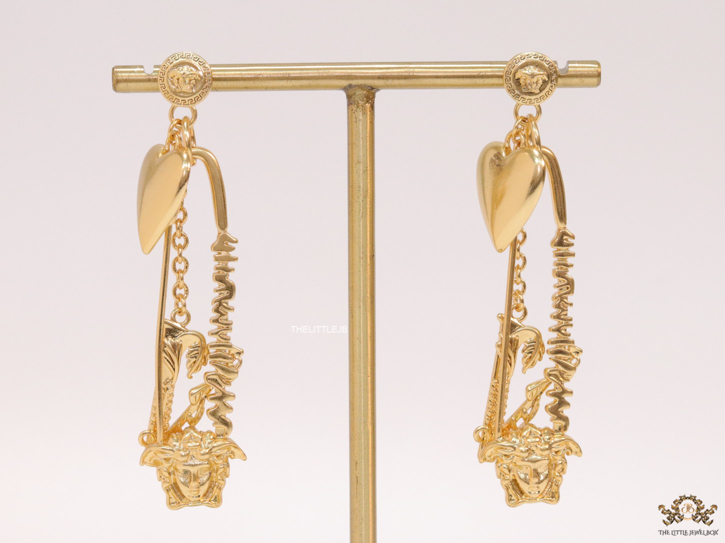 Unique golden Medusa earrings with safety pin motif