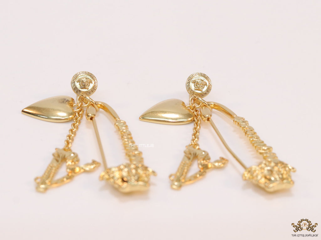 Unique golden Medusa earrings with safety pin motif