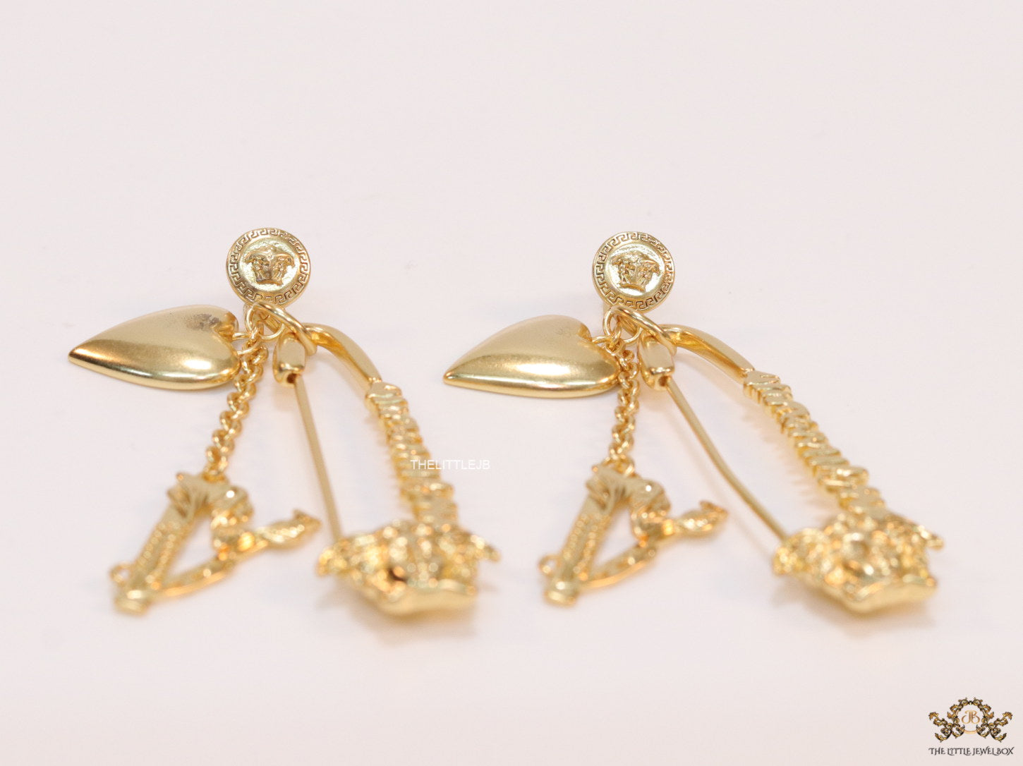 Unique golden Medusa earrings with safety pin motif