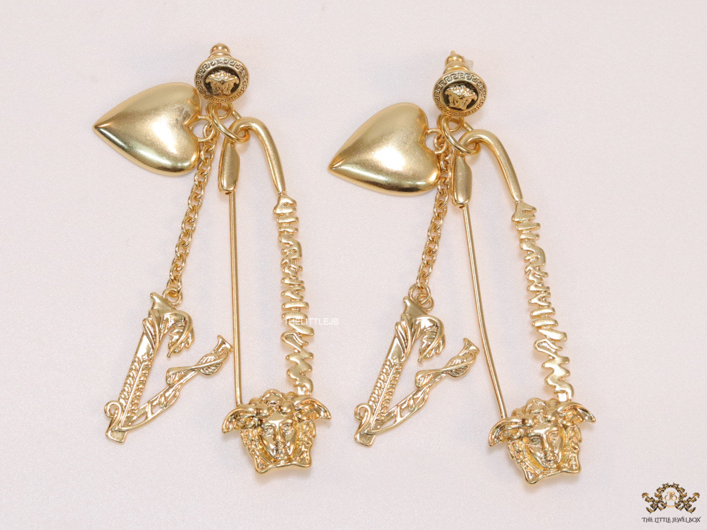 Unique golden Medusa earrings with safety pin motif