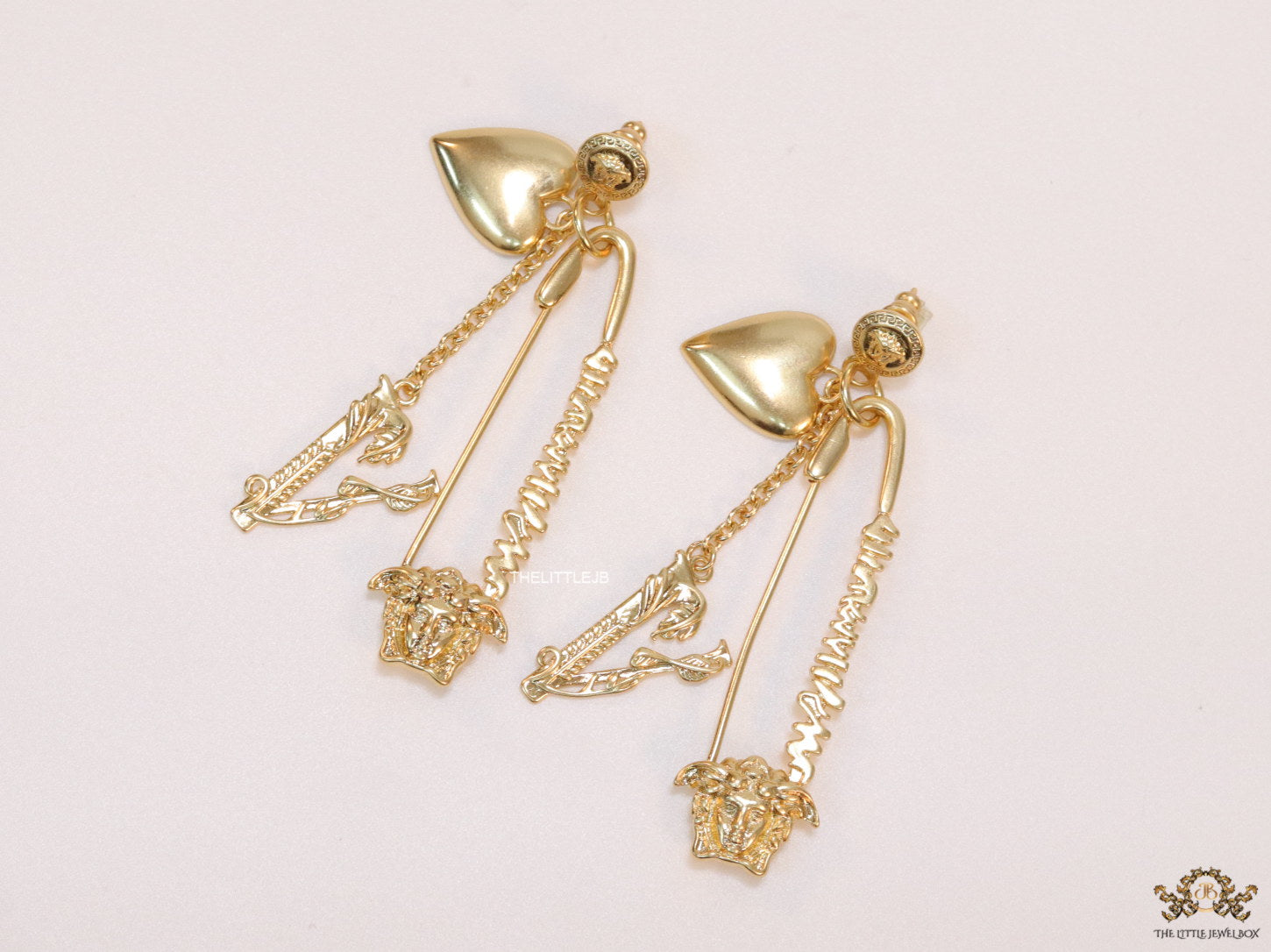 Unique golden Medusa earrings with safety pin motif