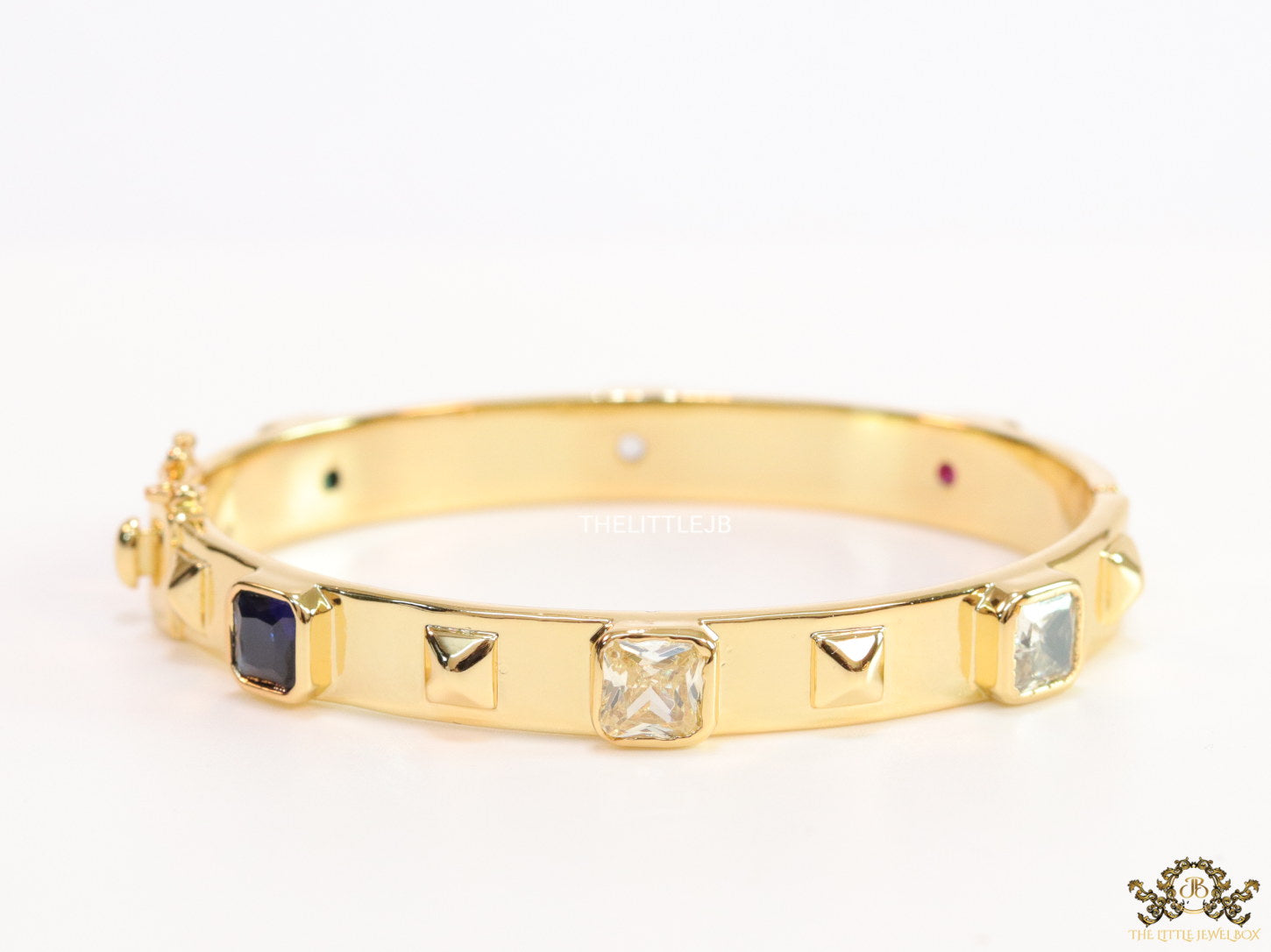Band style bracelet in gold plating with gold plated details and multi colour stones