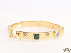 Band style bracelet in gold plating with gold plated details and multi colour stones