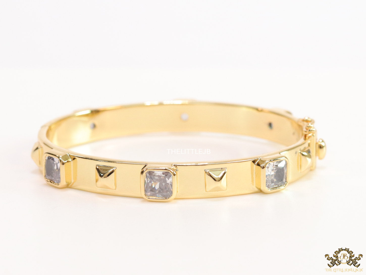Band style bracelet in gold plating with gold plated details and cubic zirconia stones