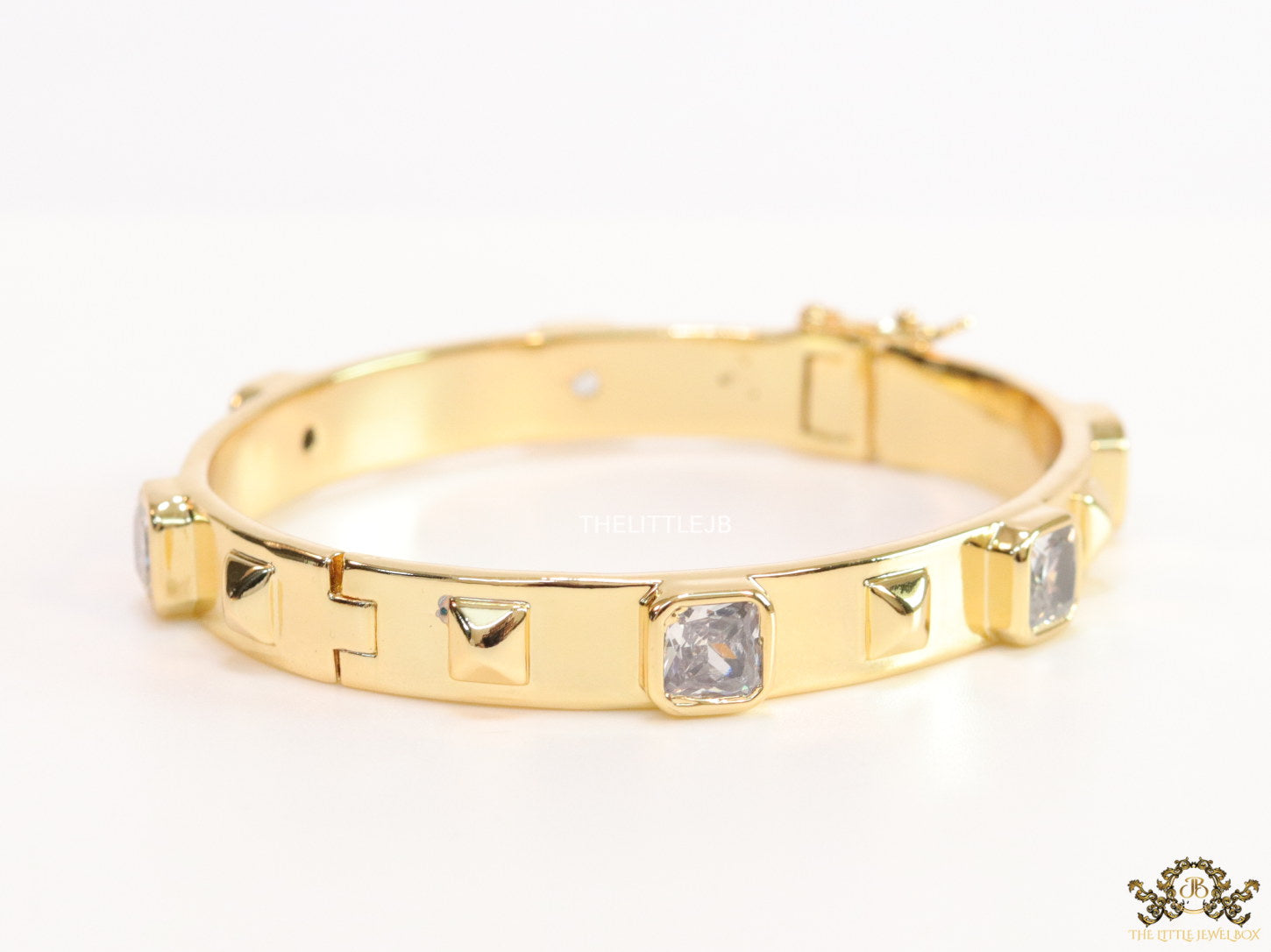 Band style bracelet in gold plating with gold plated details and cubic zirconia stones