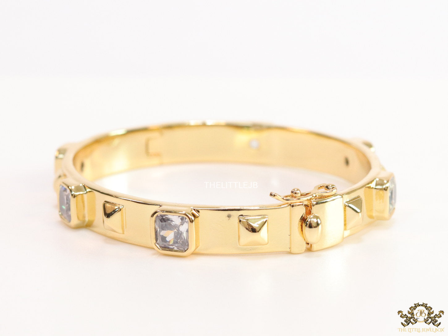 Band style bracelet in gold plating with gold plated details and cubic zirconia stones