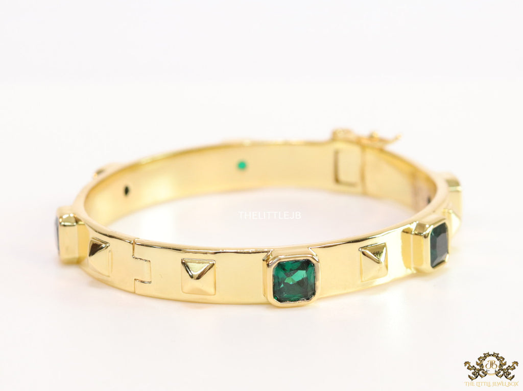 Band style bracelet in gold plating with gold plated details and emerald green colour stones