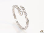 Open top platinum plated minimal serpentine bracelet with cubic zirconia stones and pearl white stones.