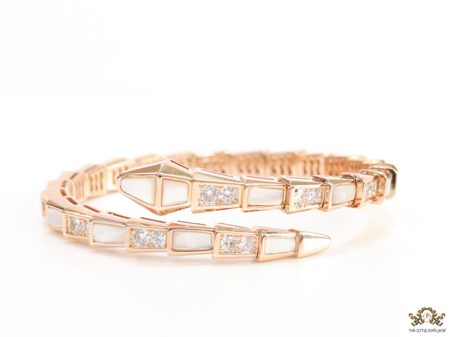Open top rose gold plated minimal serpentine bracelet with cubic zirconia stones and pearl white stones.