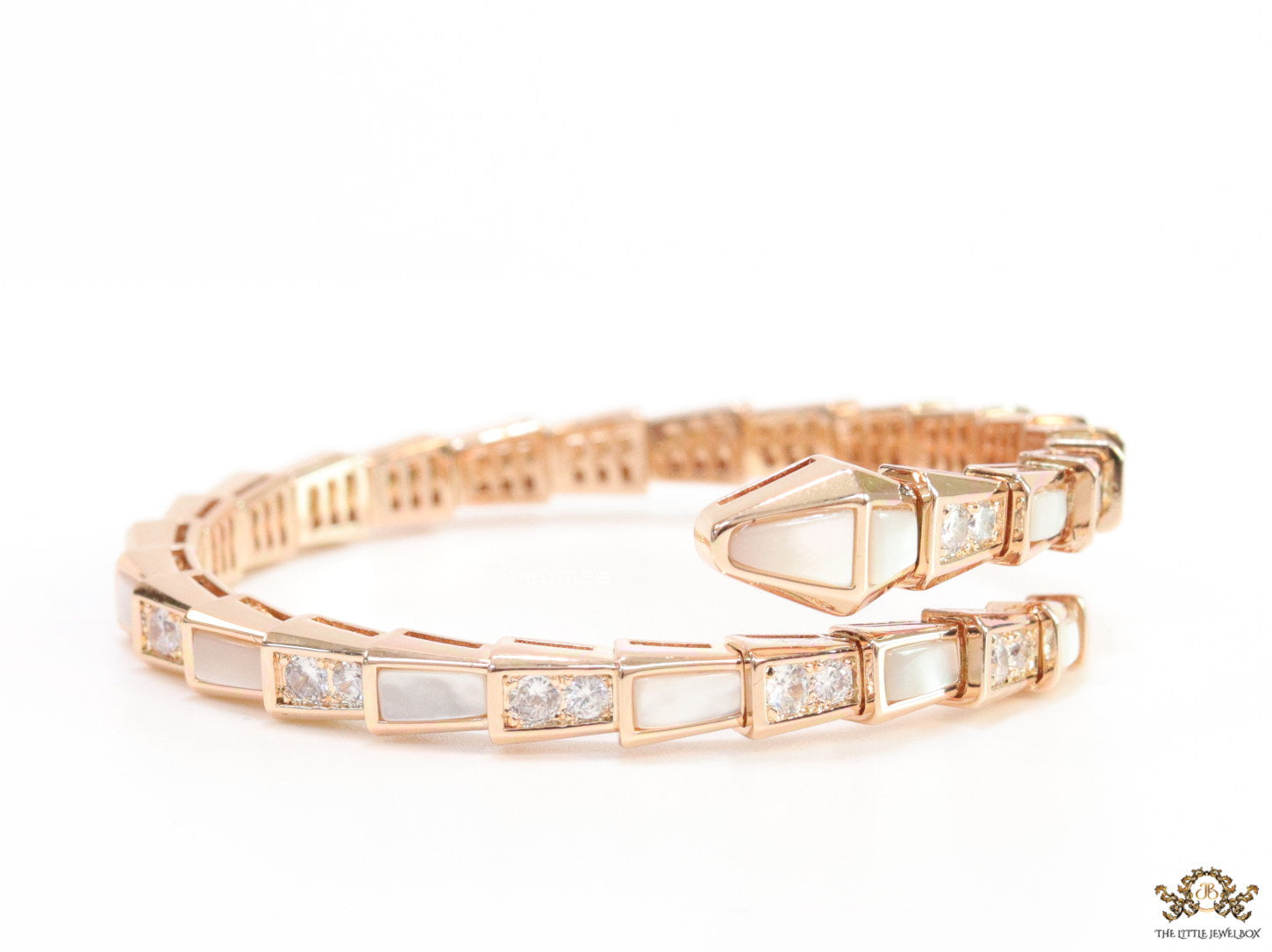Open top rose gold plated minimal serpentine bracelet with cubic zirconia stones and pearl white stones.