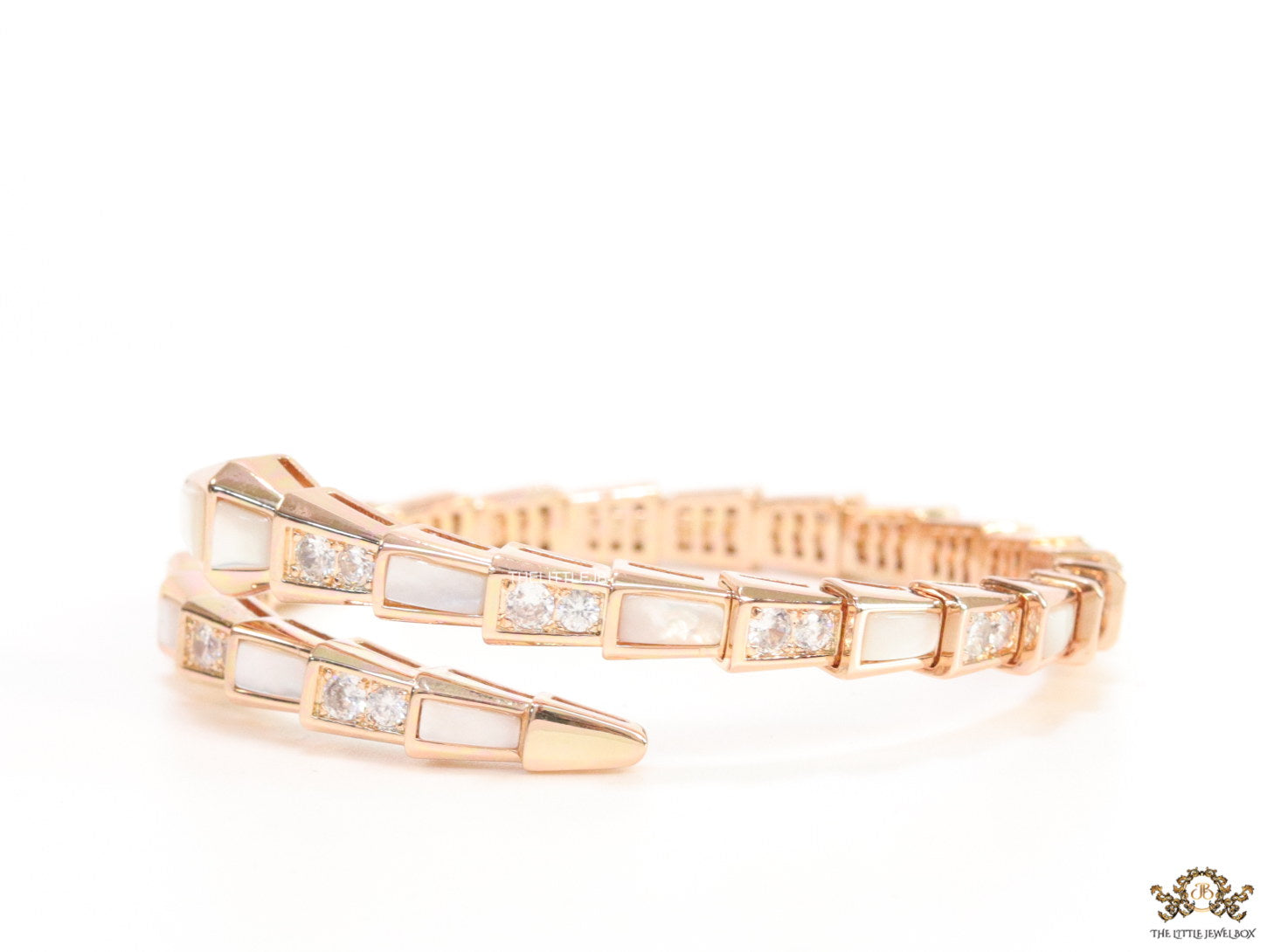 Open top rose gold plated minimal serpentine bracelet with cubic zirconia stones and pearl white stones.