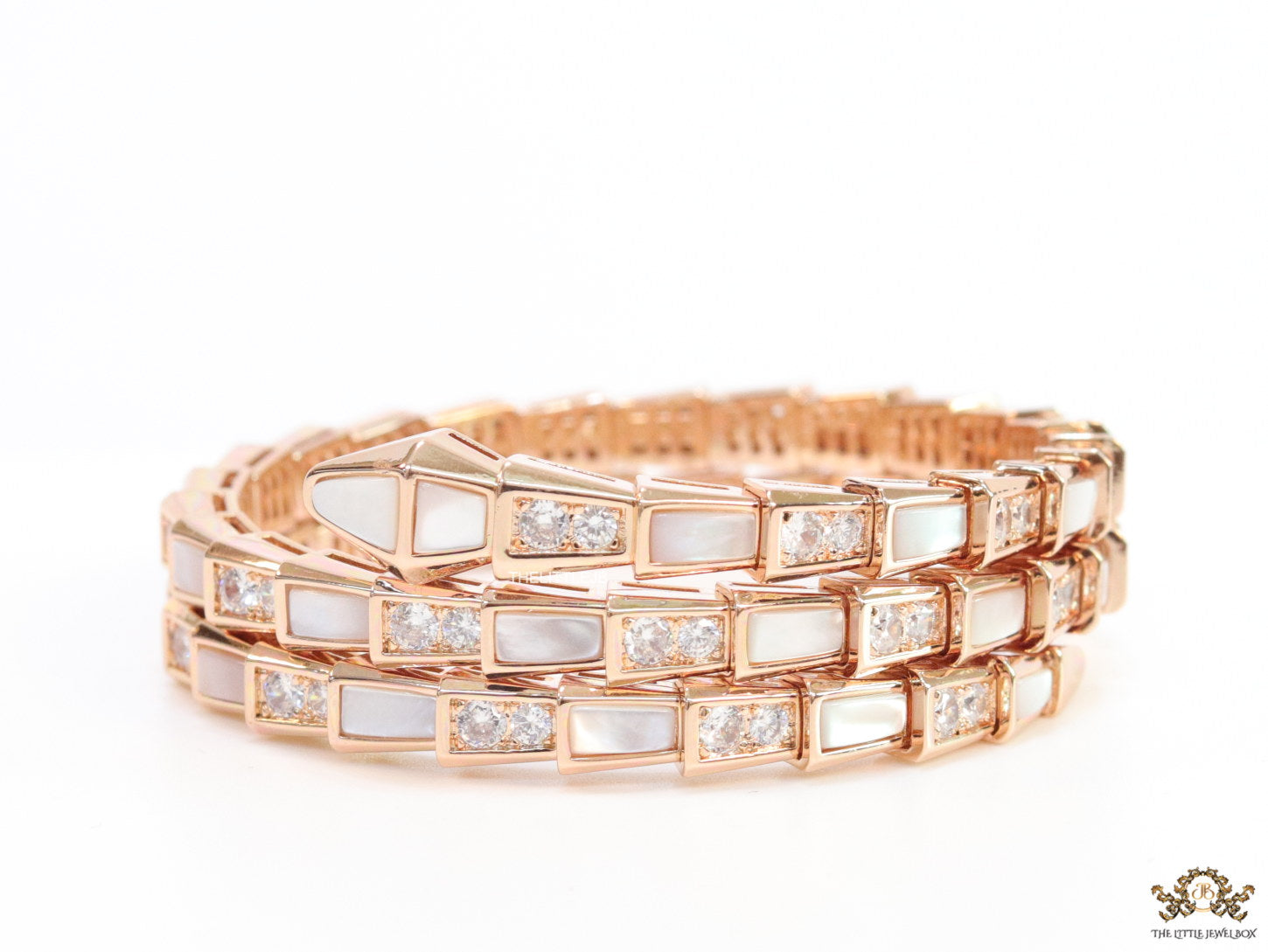 Triple line rose gold plated minimal serpentine bracelet with cubic zirconia stones and pearl white stones.