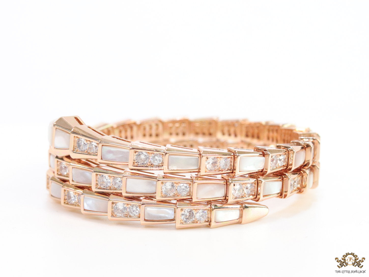 Triple line rose gold plated minimal serpentine bracelet with cubic zirconia stones and pearl white stones.