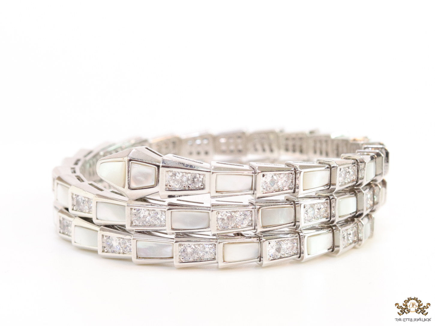 Triple line platinum plated minimal serpentine bracelet with cubic zirconia stones and pearl white stones.