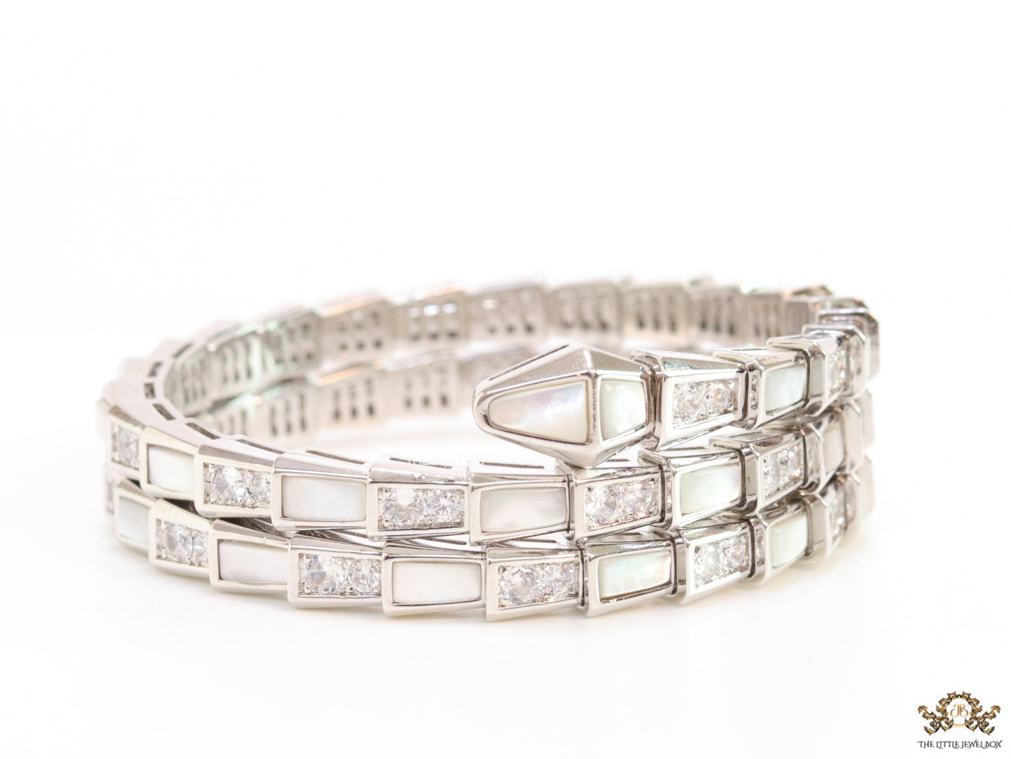 Triple line platinum plated minimal serpentine bracelet with cubic zirconia stones and pearl white stones.