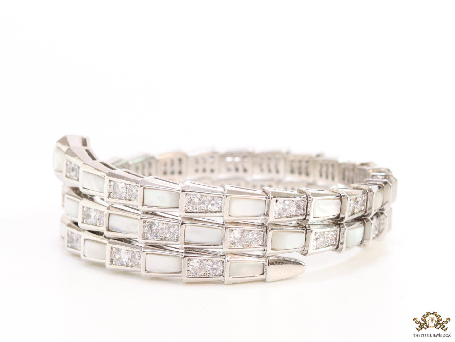 Triple line platinum plated minimal serpentine bracelet with cubic zirconia stones and pearl white stones.