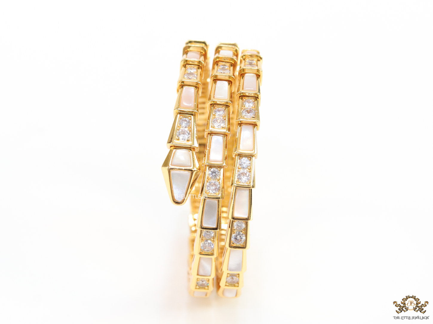Triple line gold plated minimal serpentine bracelet with cubic zirconia stones and pearl white stones.