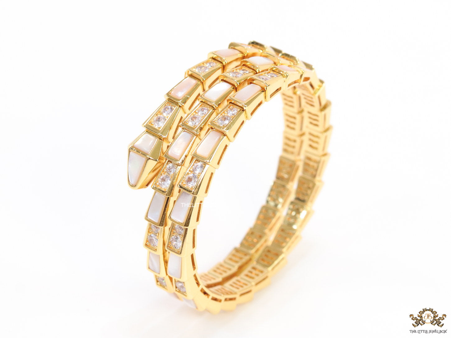 Triple line gold plated minimal serpentine bracelet with cubic zirconia stones and pearl white stones.