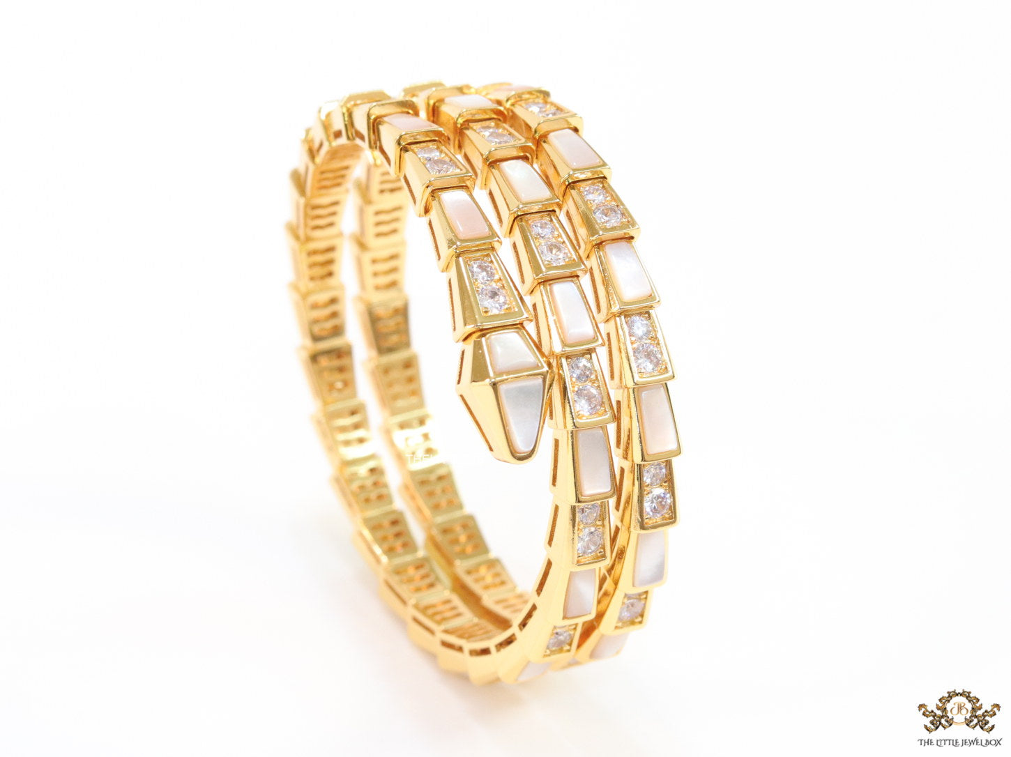 Triple line gold plated minimal serpentine bracelet with cubic zirconia stones and pearl white stones.