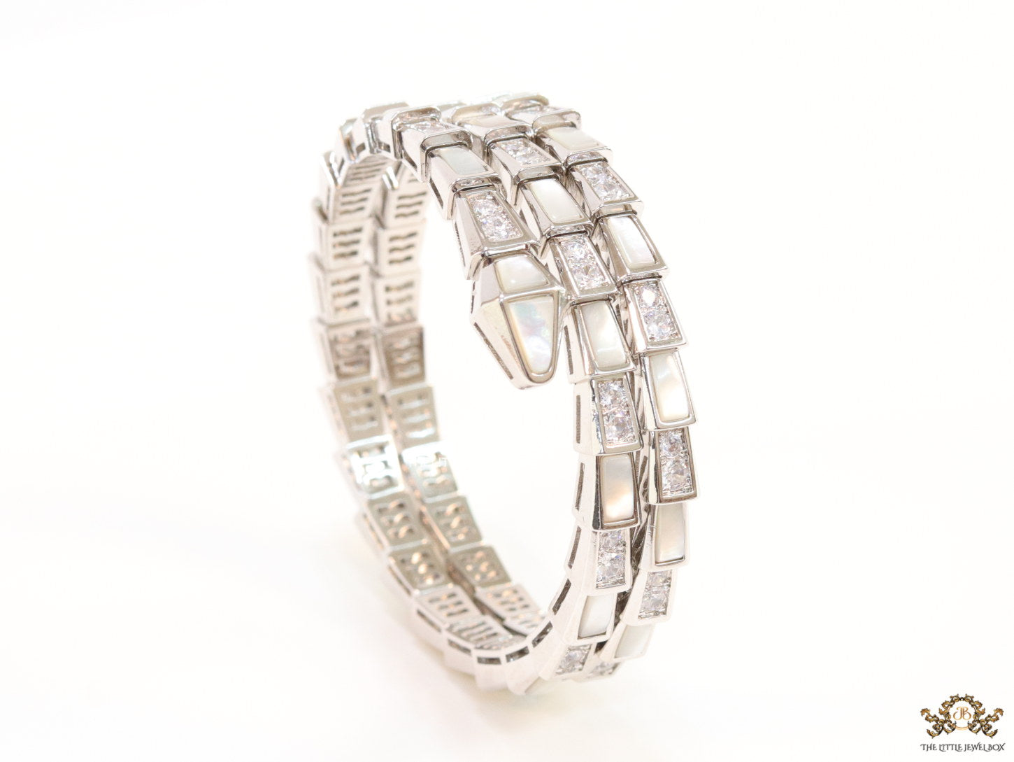 Triple line platinum plated minimal serpentine bracelet with cubic zirconia stones and pearl white stones.