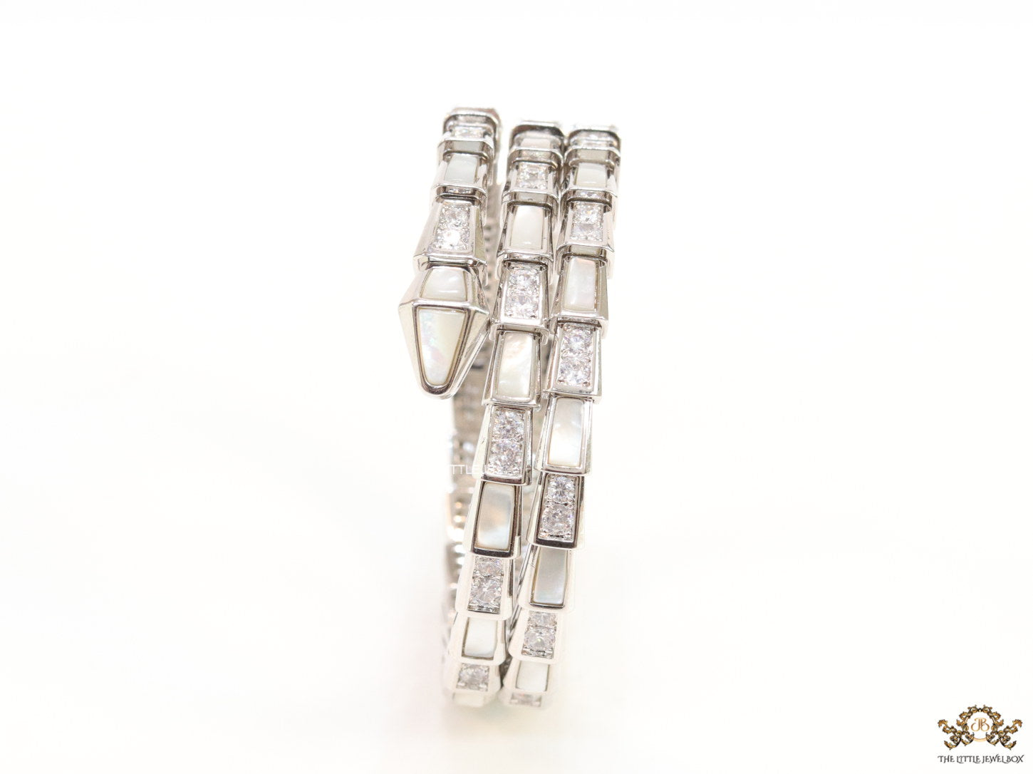 Triple line platinum plated minimal serpentine bracelet with cubic zirconia stones and pearl white stones.