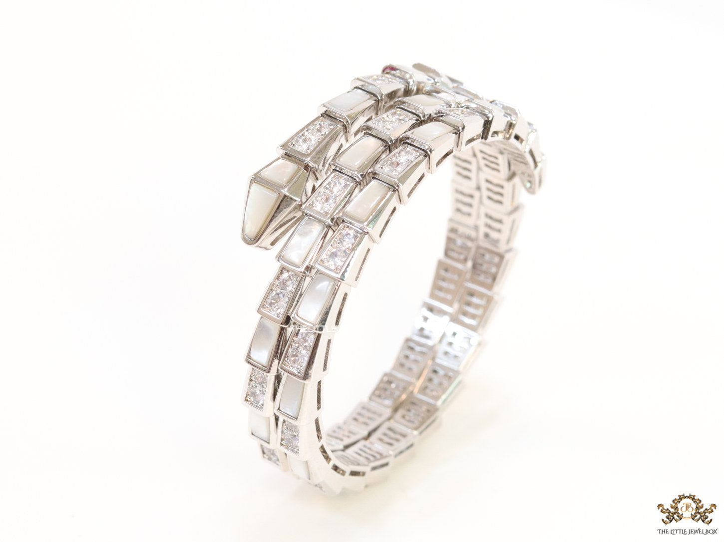 Triple line platinum plated minimal serpentine bracelet with cubic zirconia stones and pearl white stones.