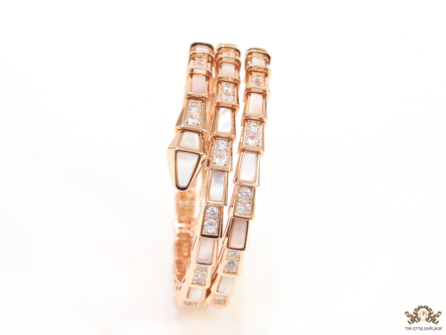 Triple line rose gold plated minimal serpentine bracelet with cubic zirconia stones and pearl white stones.